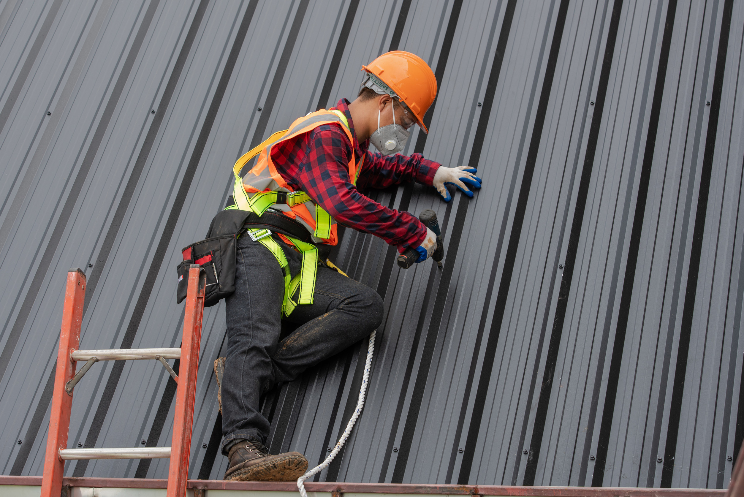 construction worker installing metal sheet roof at the construct